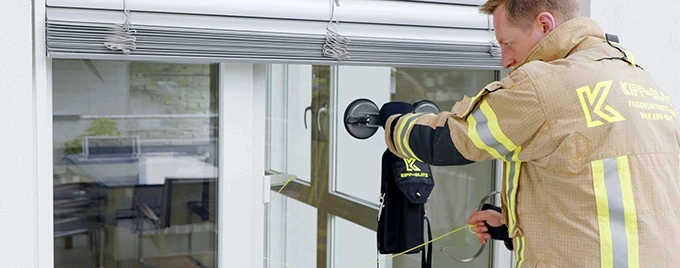 Feuerwehrmann öffnet Fenster Feuerwehrmann öffnet ein gekipptes Fenster mit dem Kipp-Blitz Öffnungswerkzeug